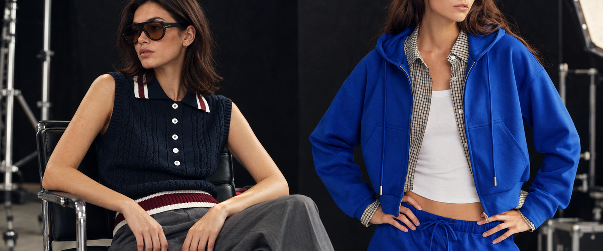 Frauen in einem dunkelblauen Strick-Poloshirt und einem blauen Hoodie