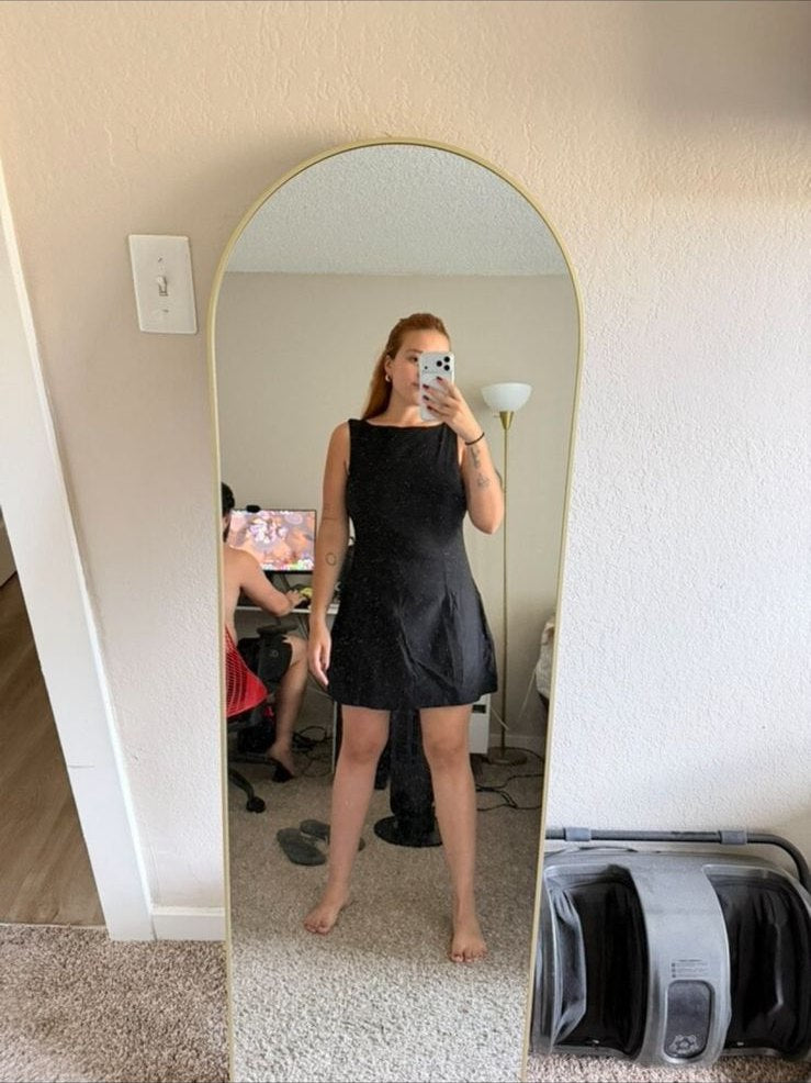 Person in einem strukturierten schwarzen Minikleid zu Hause
