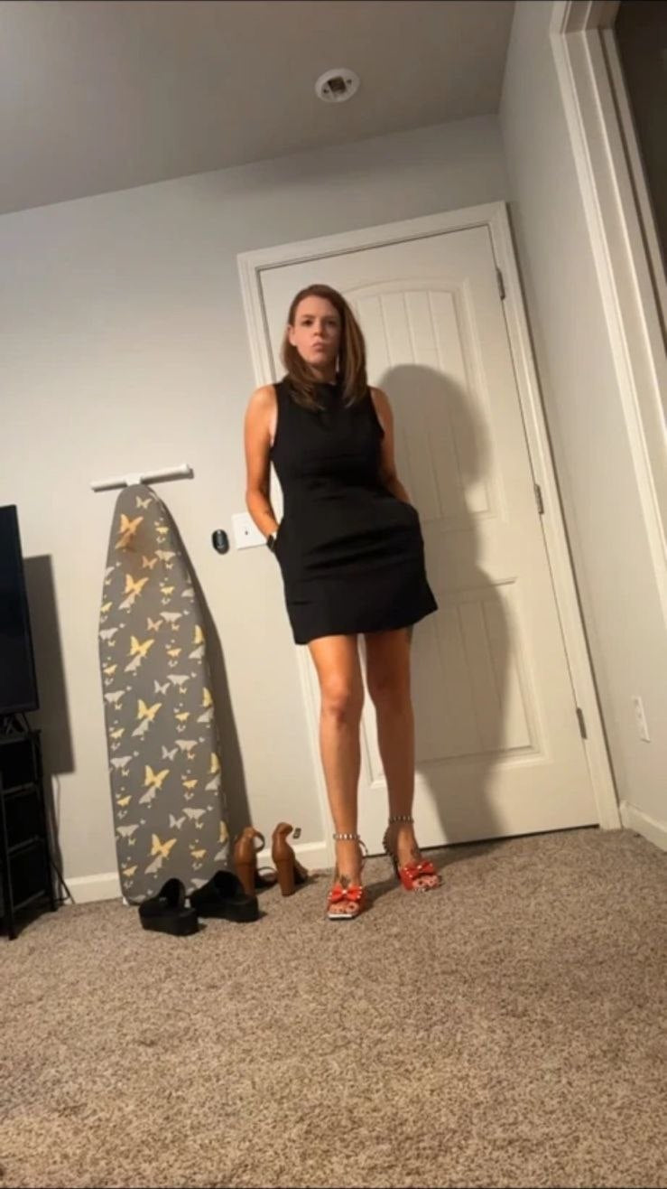 Person in einem figurbetonten schwarzen Minikleid